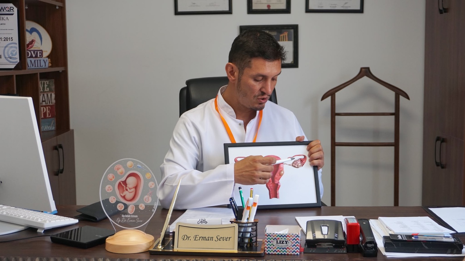 Dr. Erman Sever explaining treatment with an anatomy illustration
